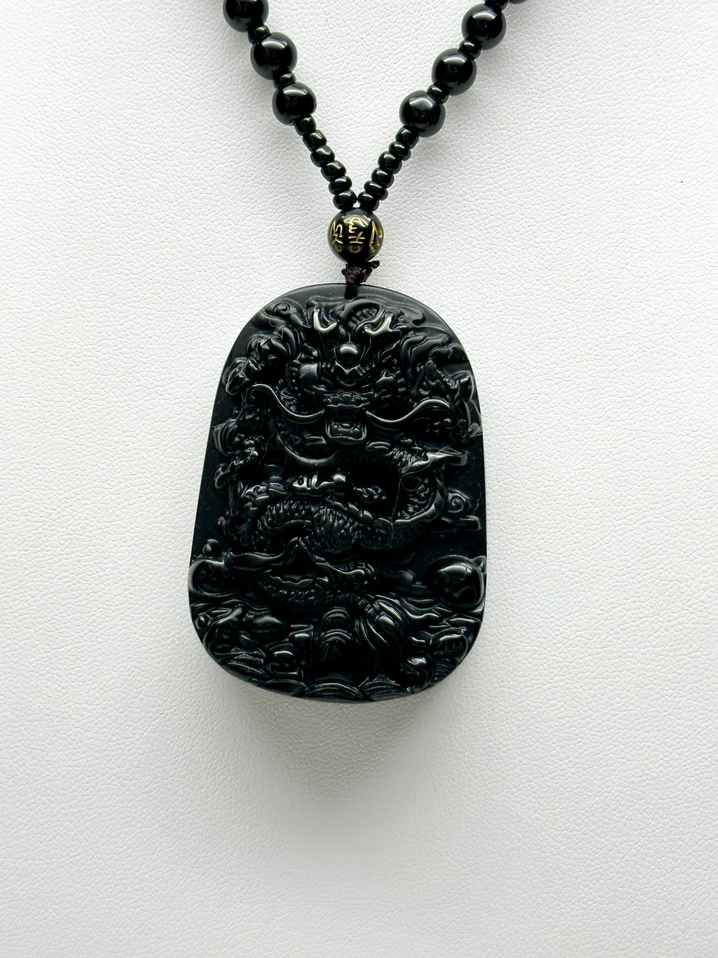 Black Obsidian Crystal Carved Dragon pendant adorning a stunning beaded necklace/Mala