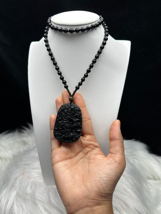 Black Obsidian Crystal Carved Dragon pendant adorning a stunning beaded necklace/Mala