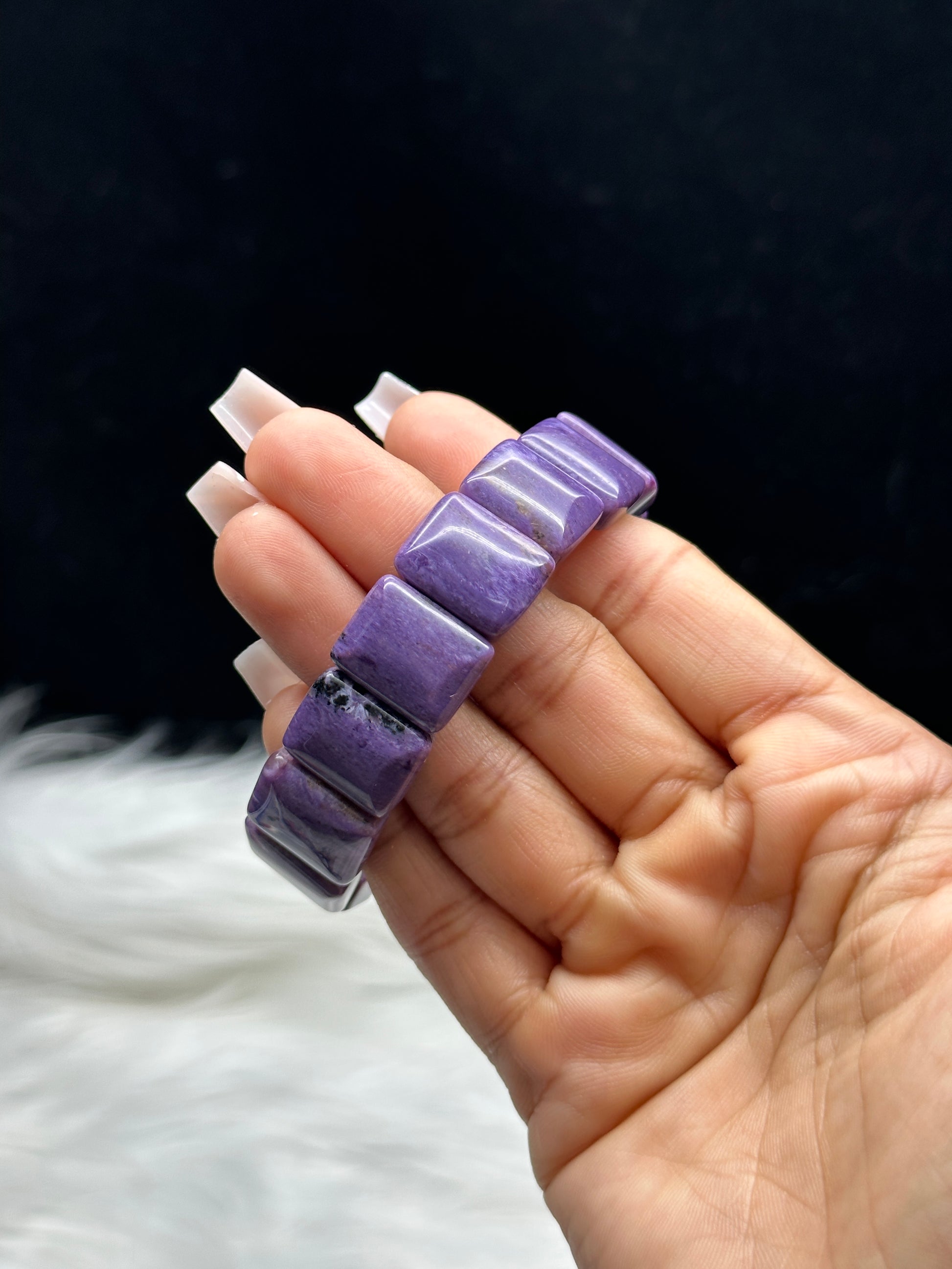 Natural charoite crystal bangle bracelet - rectangular tablet beads held in hand, close-up