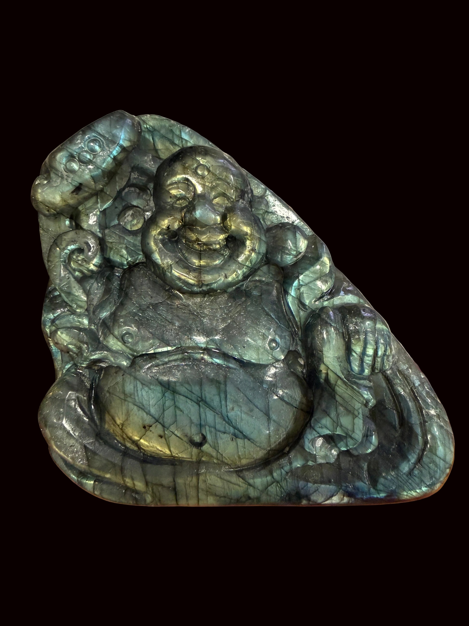 Labradorite Buddha carving held in hand showing size and flash