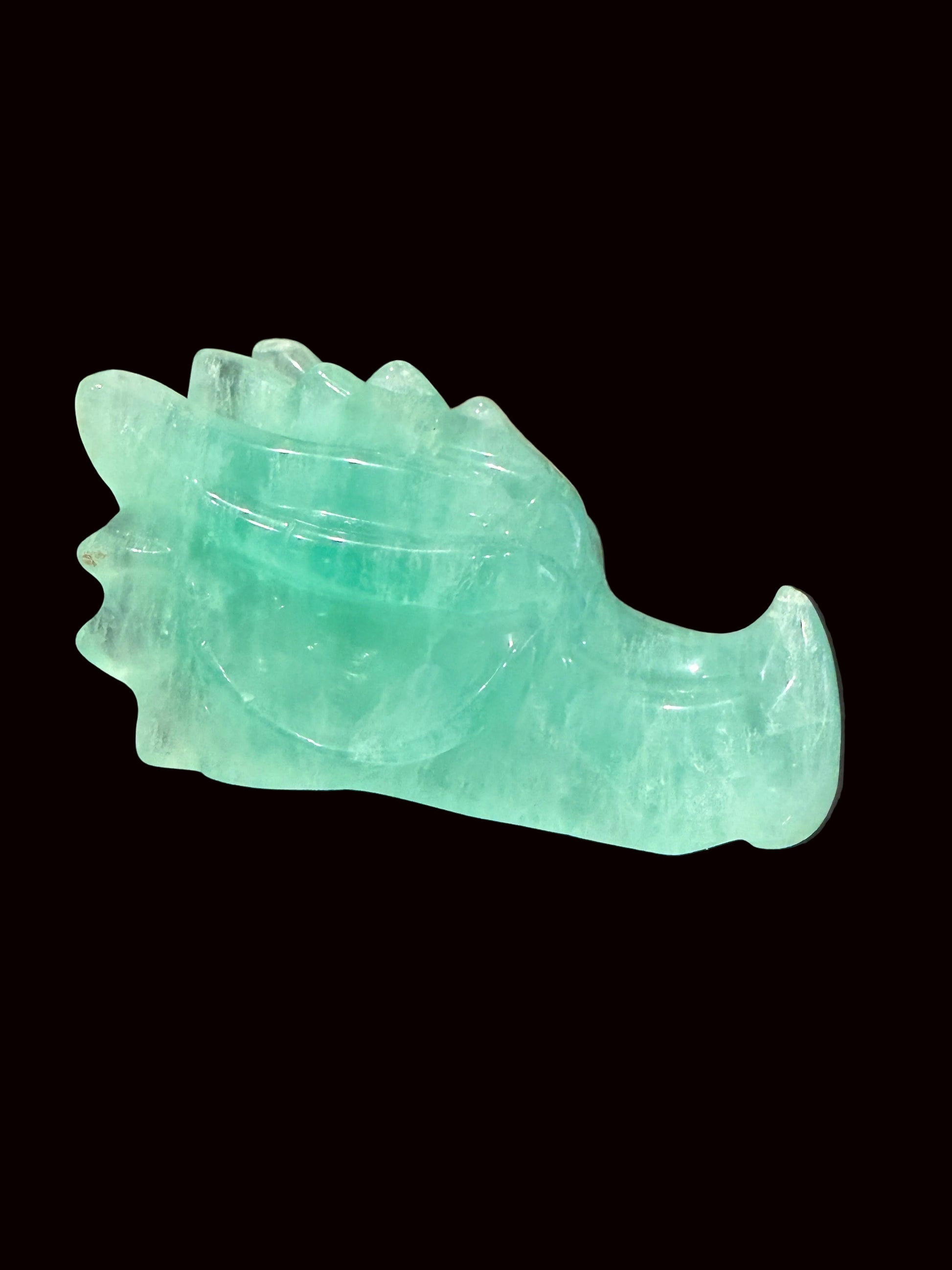 Green fluorite crystal dragon head carving lifestyle side view