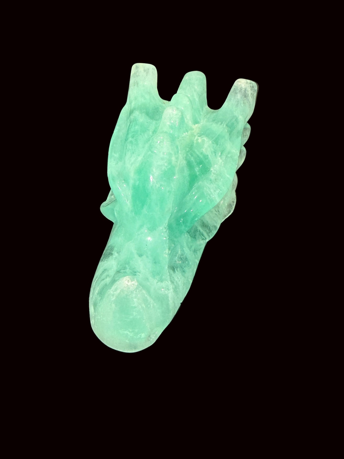 Green fluorite crystal dragon head carving top-down view showing horns
