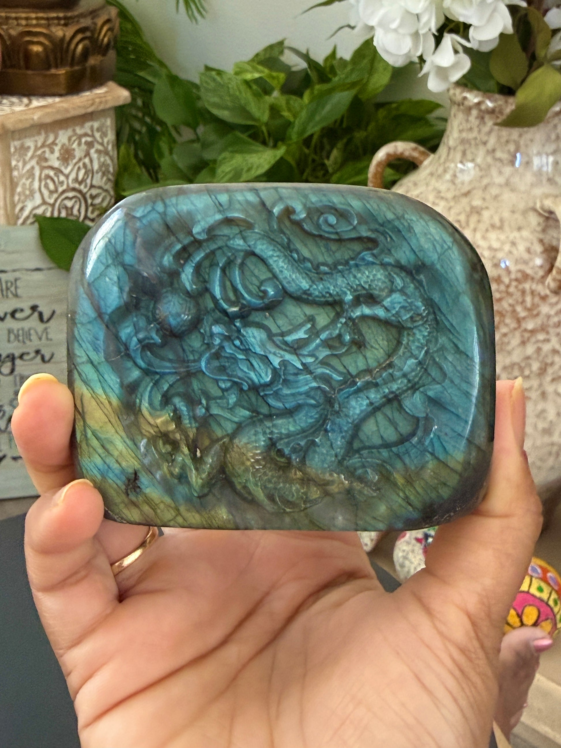 Labradorite freeform dragon carving held in hand showing blue flash and dragon relief detail