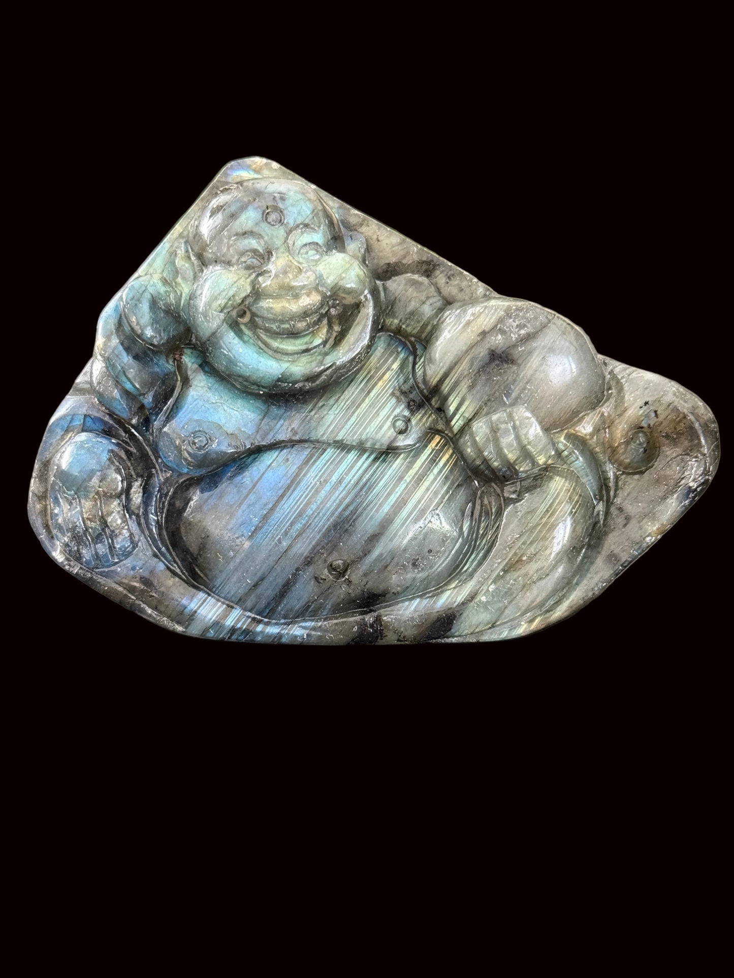 Labradorite laughing Buddha carving standing on dark table showing blue-green flash and front detail