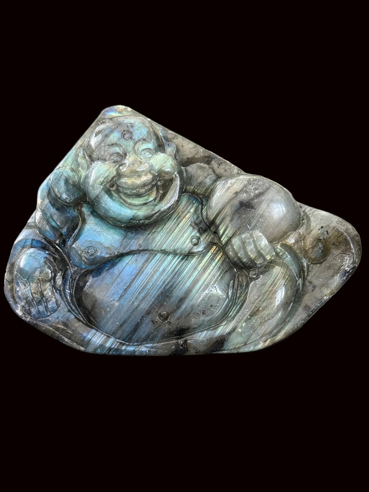 Labradorite laughing Buddha carving front view on dark table showing full flash and chatoyant banding