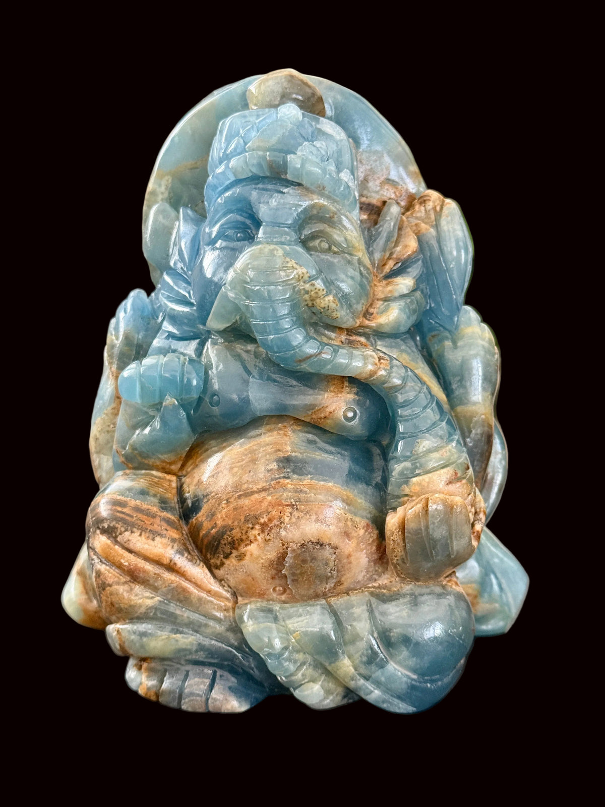 Blue onyx Ganesha carving side view showing crown halo and lotus throne detail