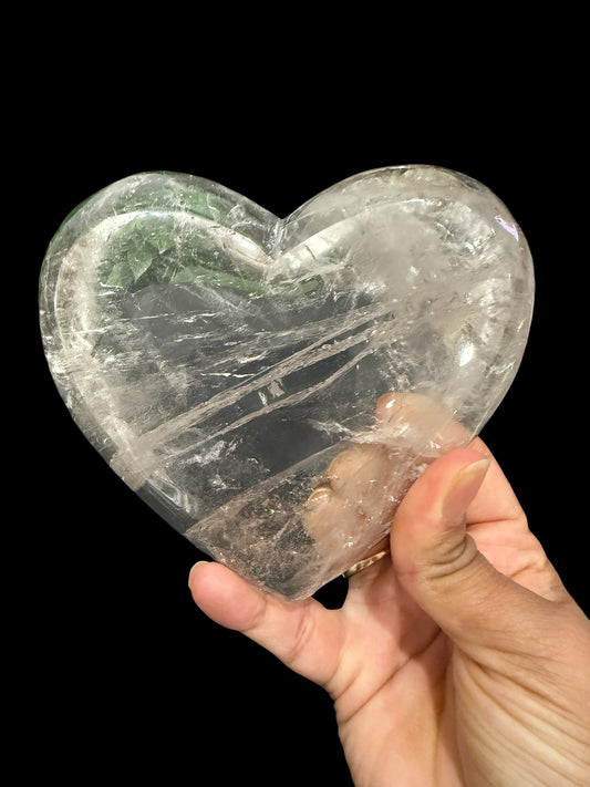 Natural clear quartz crystal heart bowl - held in hand showing size and silky inclusions