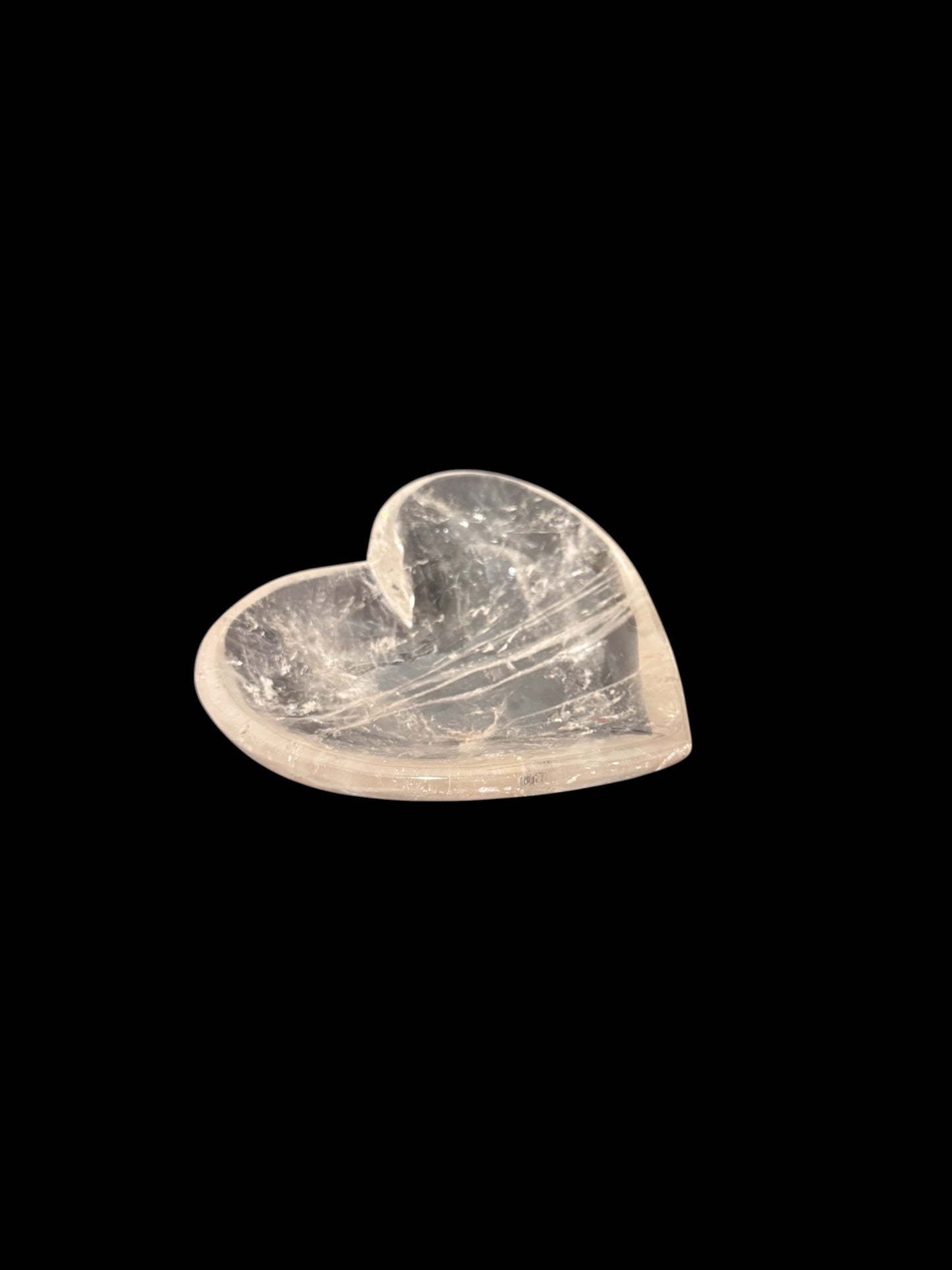 Natural clear quartz crystal heart bowl - side angled view on black background
